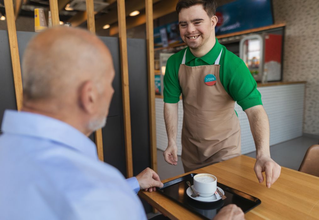 Happy,Waiter,With,Down,Syndrome,Serving,Coffee,To,Senior,Customer