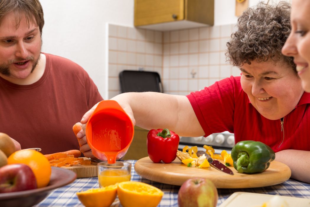 A,Mentally,Disabled,Woman,And,Two,Caretakers,Cooking,Together